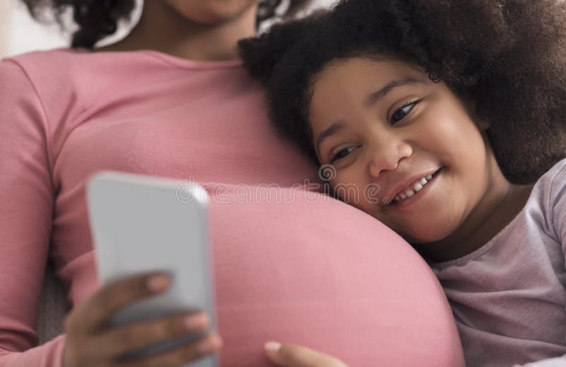 Pregnant Black Woman And Her Little Daughter Using Smartphone At Home Stock Image Image Of