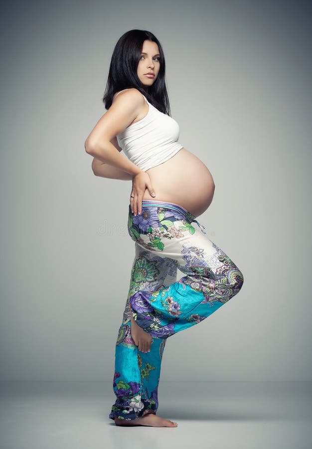 Pregnant brunette woman in sportswear.