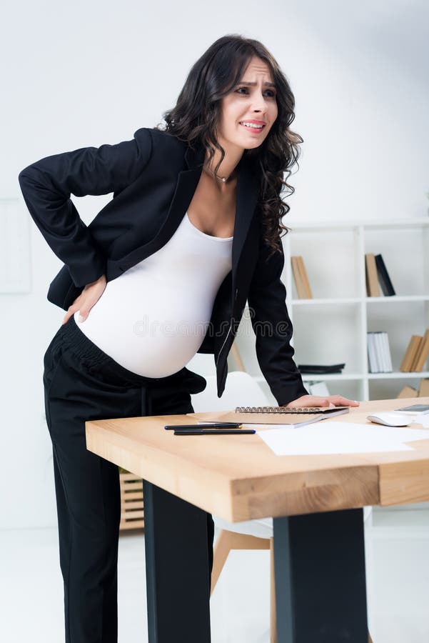 pregnant businesswoman with back pain at workplace in modern royalty free stock photography pregnant businesswoman with back pain at workplace in modern royalty free stock photography