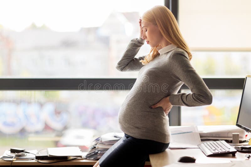 Pregnant businesswoman feeling sick at office work