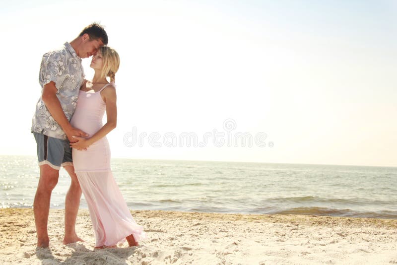 Pregnant couple in love on the beach