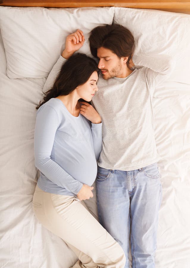 Pregnant Couple Sleeping Together in Comfortable Bed Stock Image