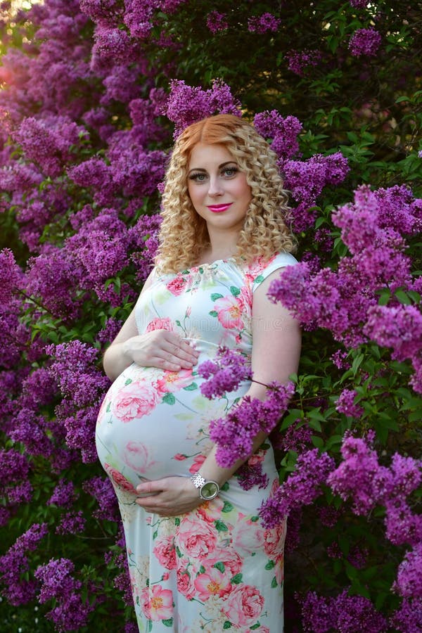 Pregnant Girl Smiling in a Blooming Spring Park, the Girl is Walking in ...