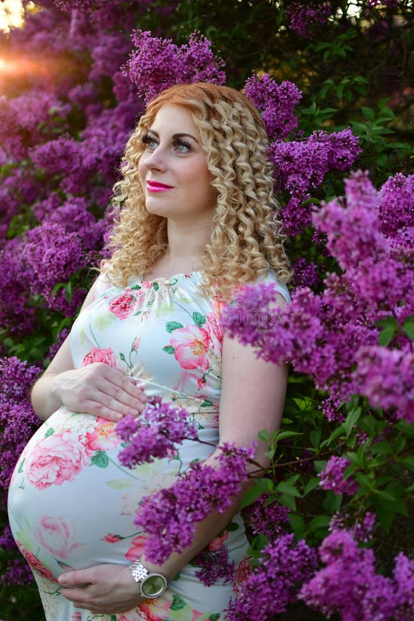 Pregnant Girl Smiling in a Blooming Spring Park, the Girl is Walking in ...