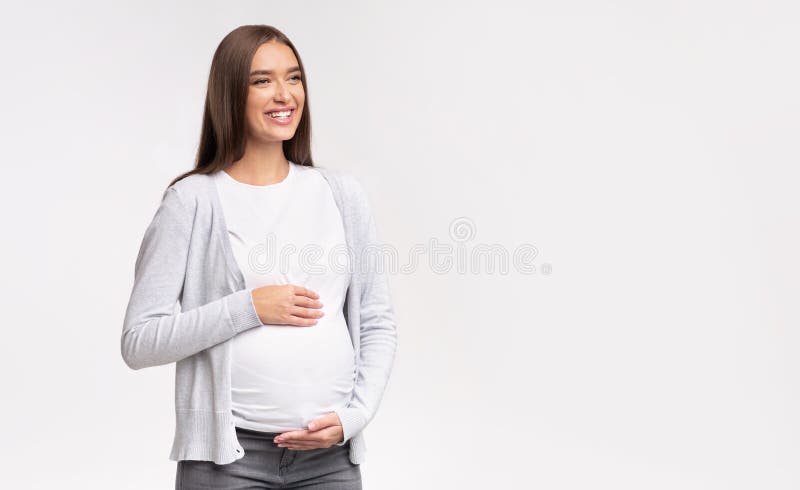 Pregnant Girl Touching Belly Looking At Free Space, Studio Shot