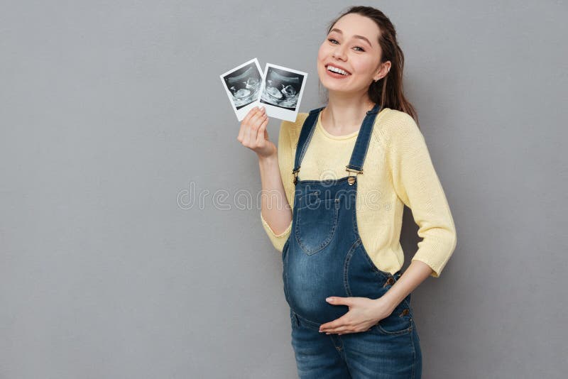 Pregnant happy woman holding ultrasound scans stock photo Pregnant happy woman holding ultrasound scans stock photo