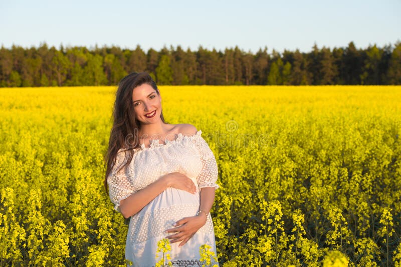 Pregnant happy woman touching her belly. Pregnant middle-aged mother portrait caressing her belly and smiling close-up. Healthy royalty free stock photo Pregnant happy woman touching her belly. Pregnant middle-aged mother portrait caressing her belly and smiling close-up. Healthy royalty free stock photo