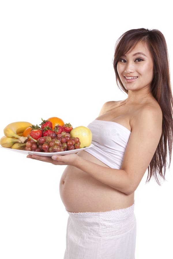 Pregnant holding plate fruit standing