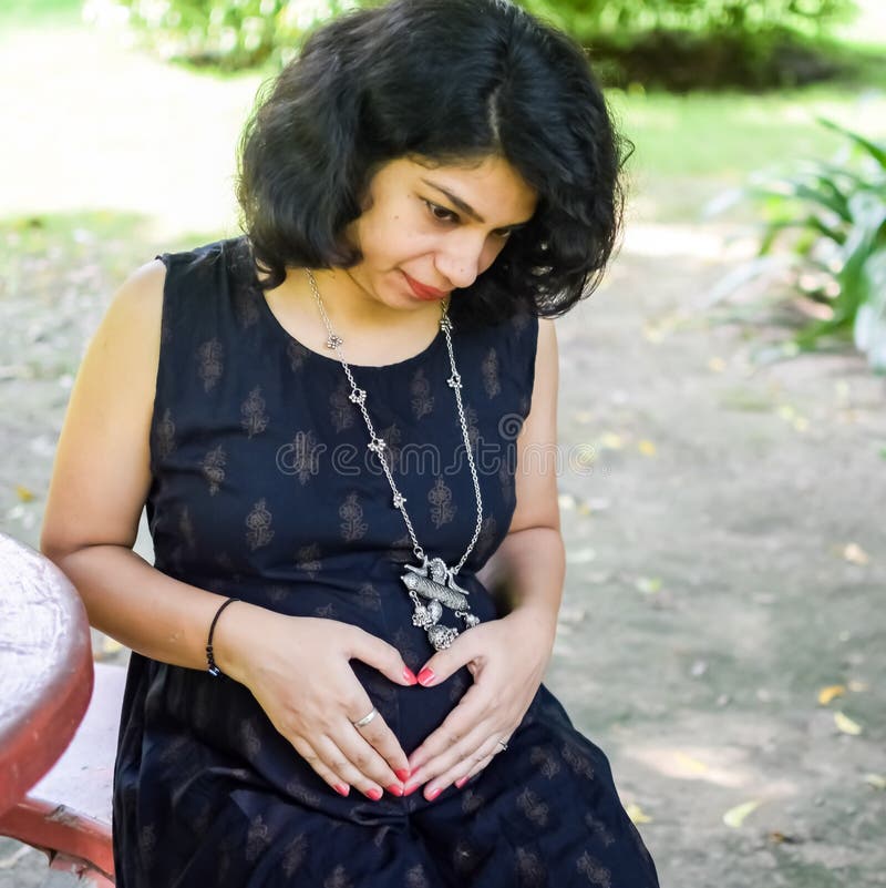 A Pregnant Indian Lady Poses for Outdoor Pregnancy Shoot and Hands
