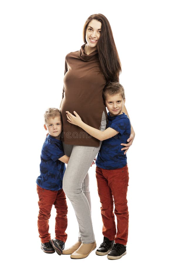 Pregnant mom and sons hug and smile, full height. Tenderness and love. Isolated on white background, vertical.