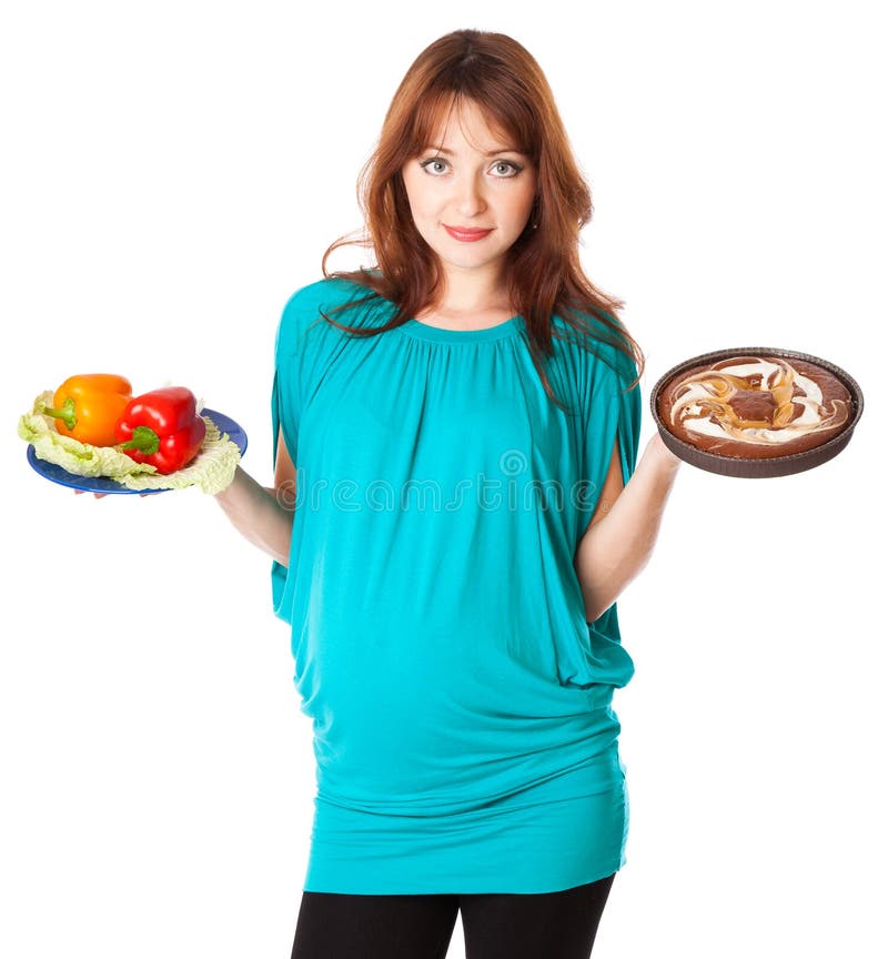 A pregnant smiling woman is holding food