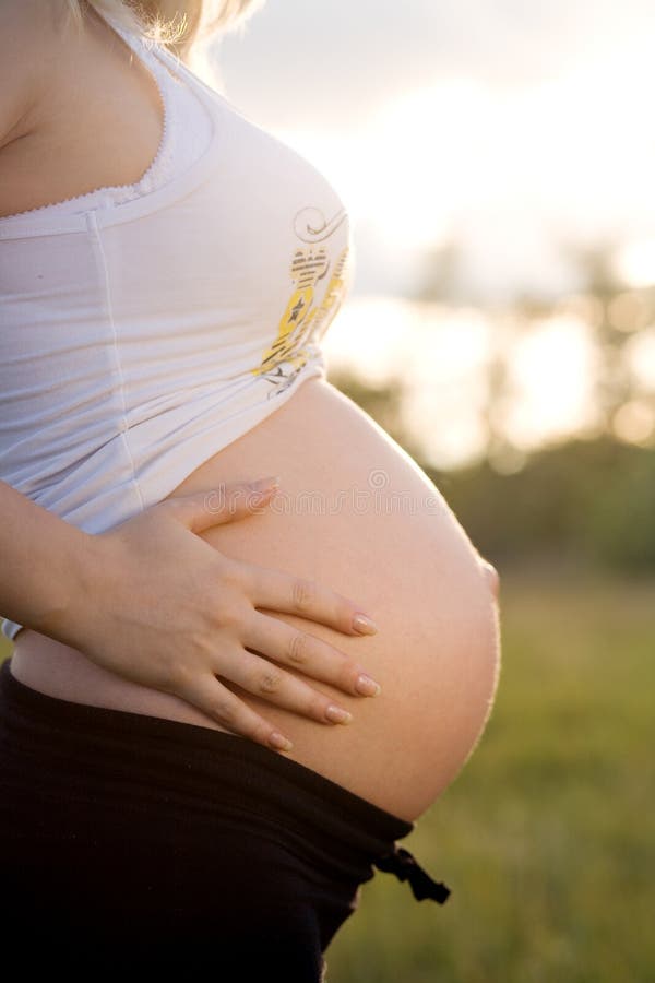 Pregnant staying and holding belly