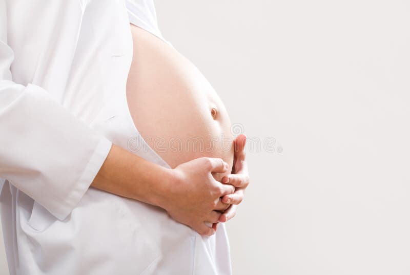 Zblízka obraz tehotnej ženy dotýkať jej bruchu s rukami.