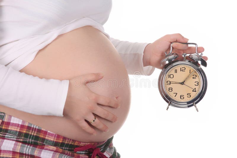 Pregnant woman with alarm clock waiting