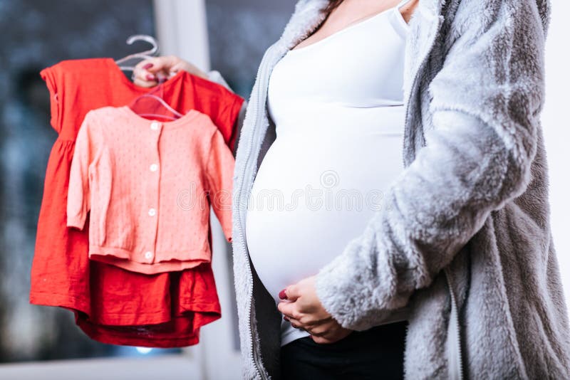 Pregnant woman with baby clothes royalty free stock photo Pregnant woman with baby clothes royalty free stock photo