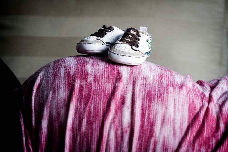 Pregnant Woman With Baby Shoes on her Belly stock photography Pregnant Woman With Baby Shoes on her Belly stock photography