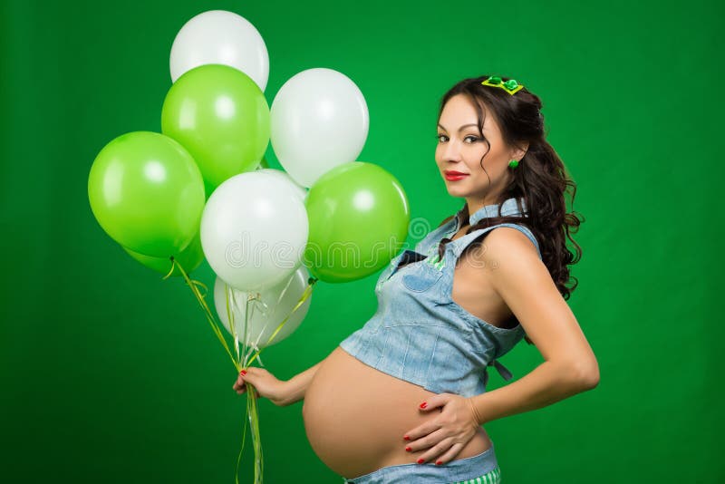 Pregnant Woman With Balloons On A Green Background He Looks At His Tummy In Anticipation Stock