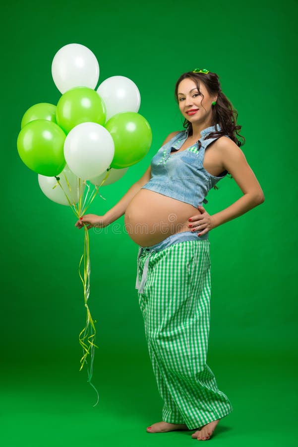 Pregnant Woman With Balloons On A Green Background He Looks At His Tummy In Anticipation Stock