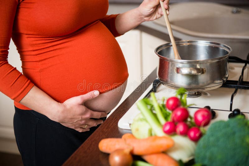 Pregnant woman cooking broccoli royalty free stock image Pregnant woman cooking broccoli royalty free stock image