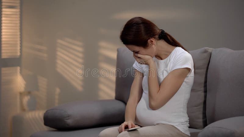 Pregnant woman crying after telephone call, bad test results, medical insurance stock photo Pregnant woman crying after telephone call, bad test results, medical insurance stock photo