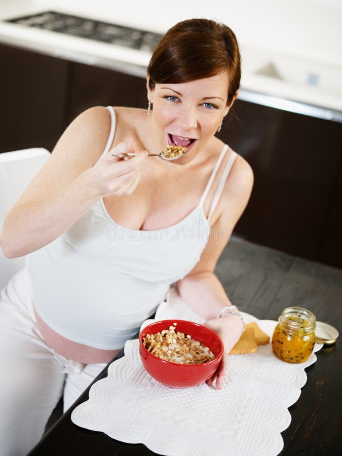 Pregnant woman doing breakfast at home