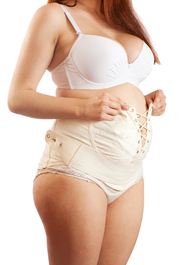 Pregnant woman dressing maternity girdle. Closeup of pregnant woman dressing maternity girdle. Isolated over white stock images Pregnant woman dressing maternity girdle. Closeup of pregnant woman dressing maternity girdle. Isolated over white stock images