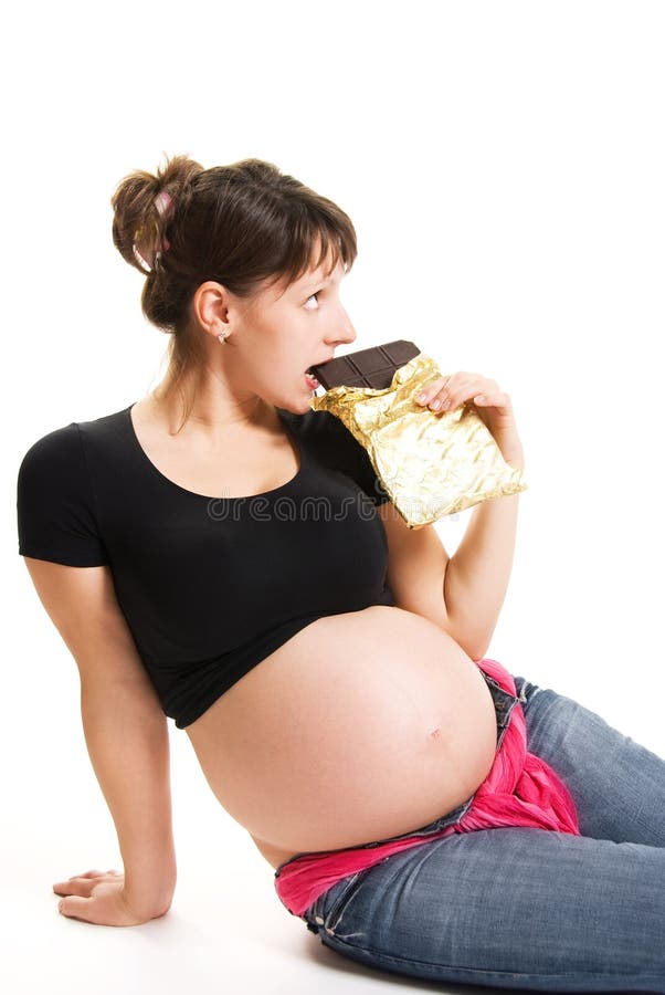Pregnant woman eating chocolate royalty free stock photo