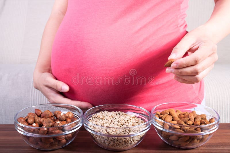 Pregnant woman eating different seeds royalty free stock images Pregnant woman eating different seeds royalty free stock images