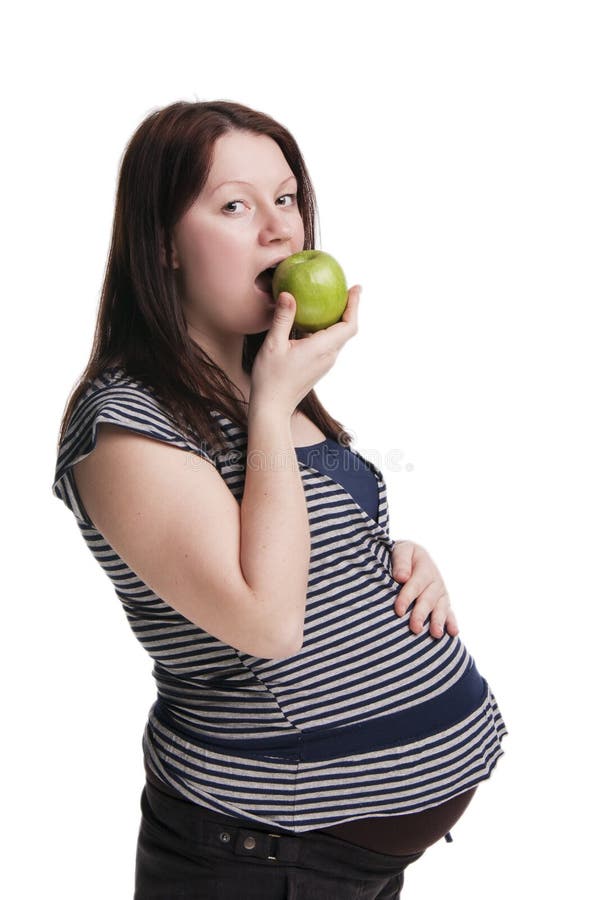 pregnant woman eating a green apple