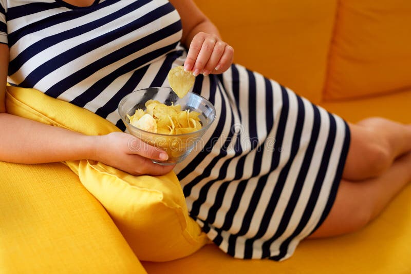 Pregnant woman eats chips stock photo. Image of potato 99357620