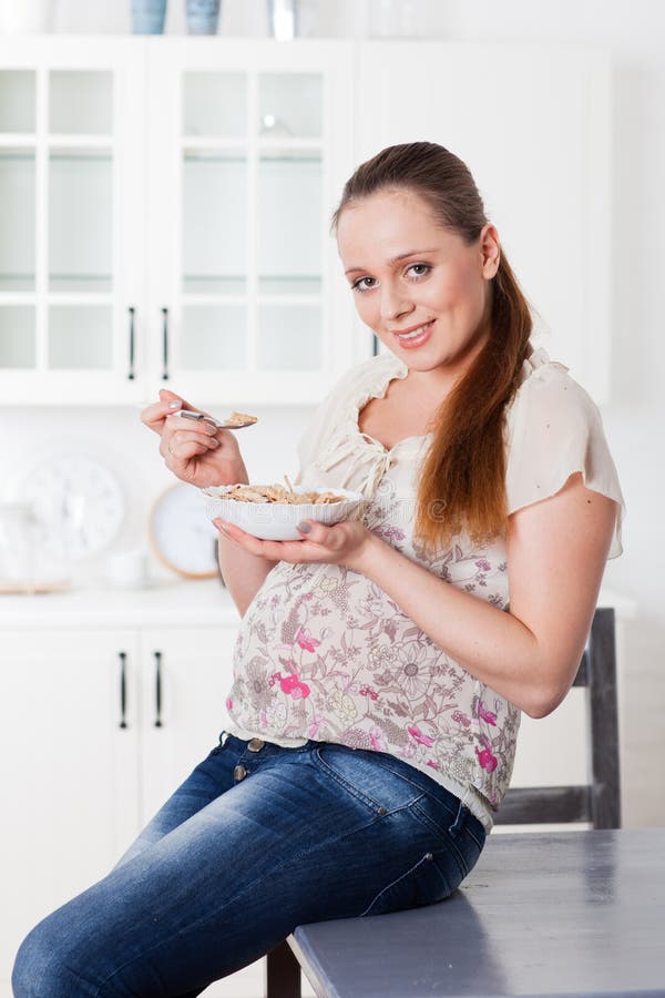 Pregnant Woman Eats Corn Flakes. Stock Photo Image of indoors