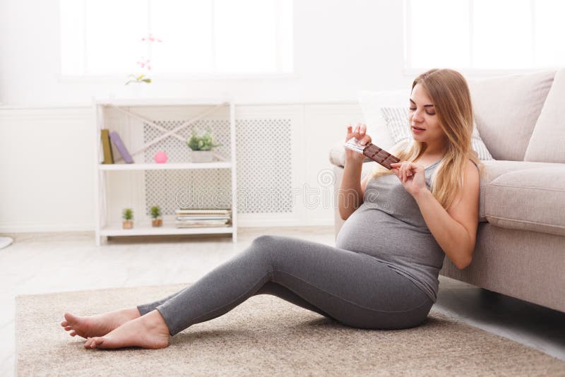 Pregnant woman enjoying of eating chocolate bar stock image Pregnant woman enjoying of eating chocolate bar stock image