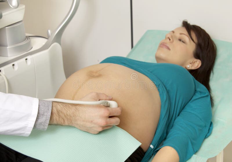 Pregnant woman getting ultrasound from doctor