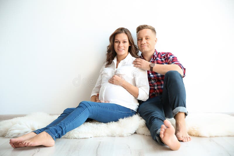 Pregnant Woman With Her Husband Near White Wall Stock Image Image Of 