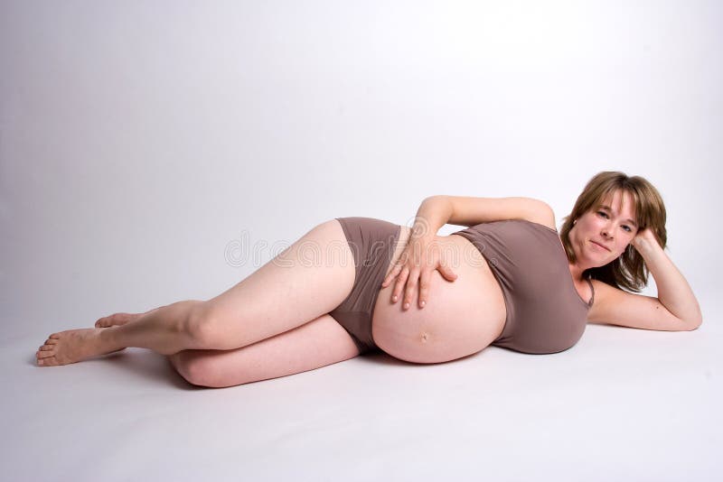 Pregnant woman on her side holding her belly