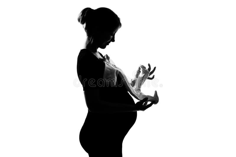 Pregnant woman holding baby clothes royalty free stock photo Pregnant woman holding baby clothes royalty free stock photo