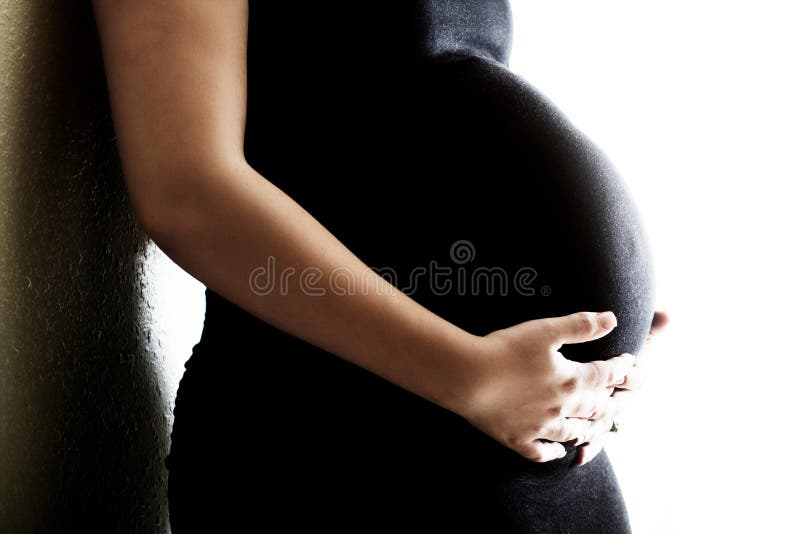 Una Donna che è di 9 mesi di gravidanza detiene il suo ventre.