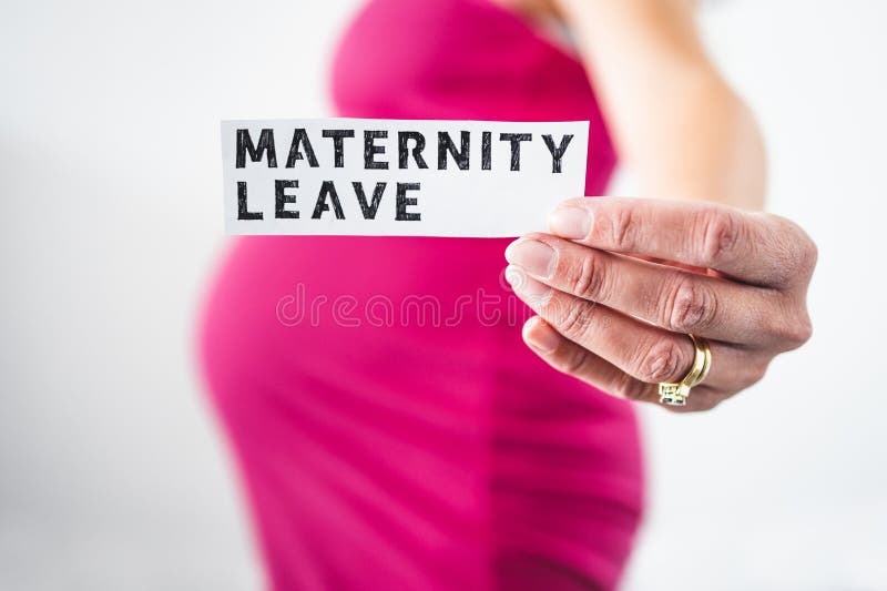 Pregnant woman holding Maternity Leave sign towards the camera wearing pink dress in the last month of pregnancy stock photo Pregnant woman holding Maternity Leave sign towards the camera wearing pink dress in the last month of pregnancy stock photo