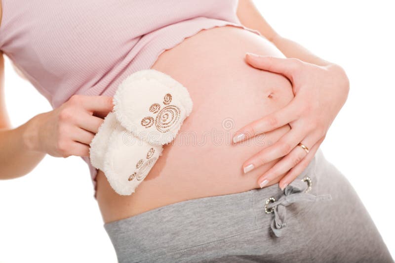 Pregnant woman holding pair of shoes for baby