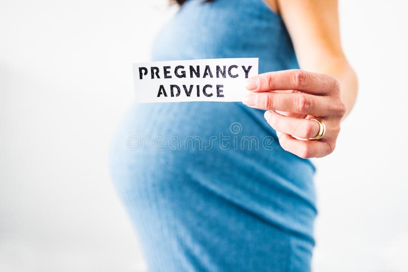 Pregnant woman holding Pregnancy Advice sign towards the camera wearing blue dress in the last month of pregnancy stock image Pregnant woman holding Pregnancy Advice sign towards the camera wearing blue dress in the last month of pregnancy stock image