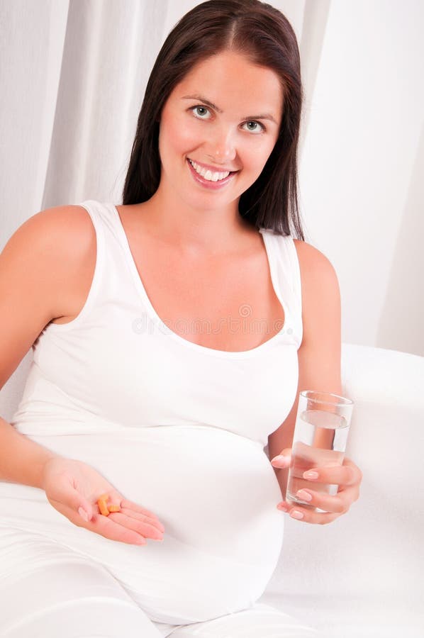 Pregnant woman holds a medical tablet