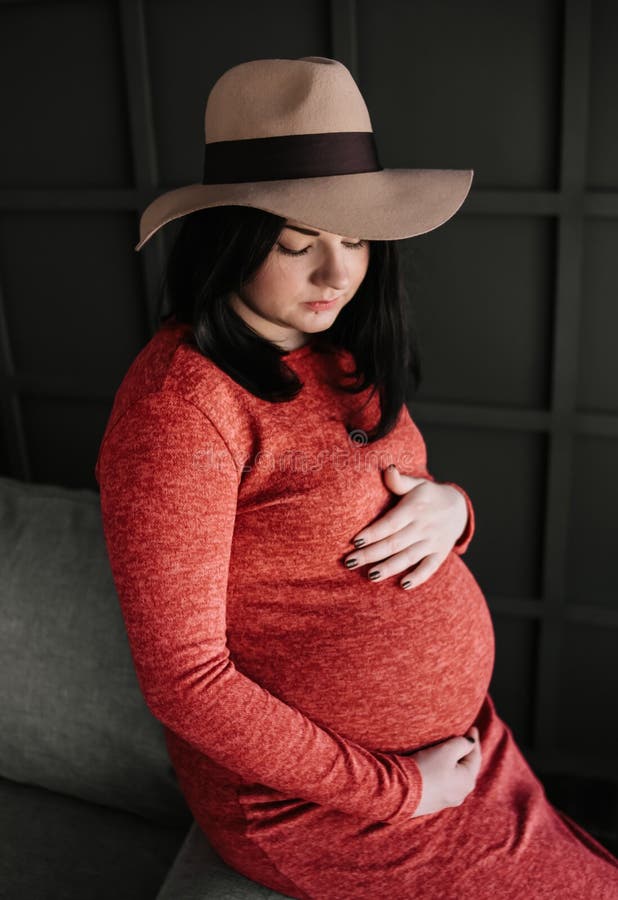 Pregnant woman inside room gently strokes belly royalty free stock photography Pregnant woman inside room gently strokes belly royalty free stock photography