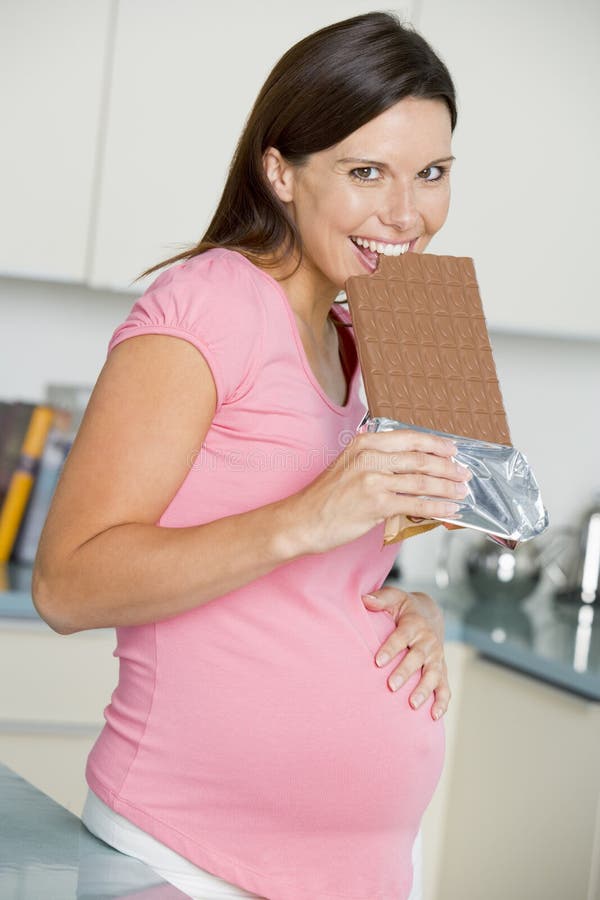 Pregnant Woman in Kitchen with Large Chocolate Bar Stock Photo Image