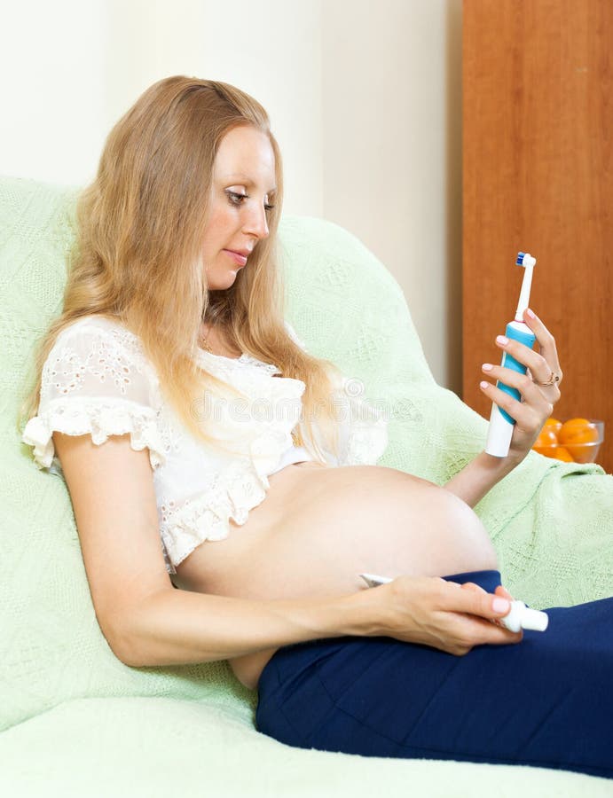 Pregnant woman looking tooth brush at home