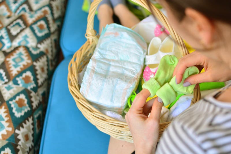 Woman packing diaper bag in maternity hospital. Stock Photo by