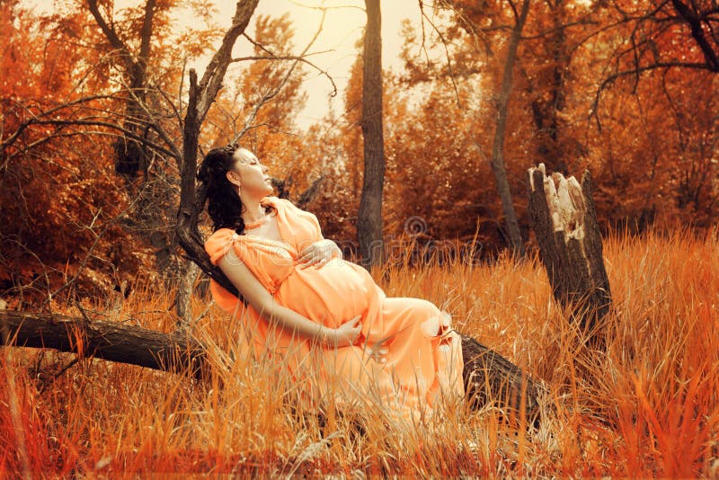 Pregnant woman in red forest
