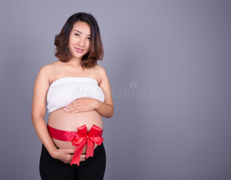 Pregnant woman with red ribbon on belly stock image Pregnant woman with red ribbon on belly stock image