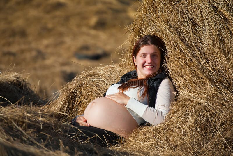 Pregnant woman resting on hay royalty free stock photos