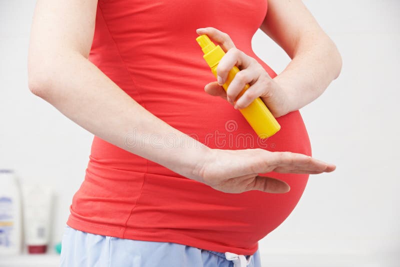 Pregnant Woman Spraying Mosquito Repellent To Protect Against Zika Virus royalty free stock image Pregnant Woman Spraying Mosquito Repellent To Protect Against Zika Virus royalty free stock image