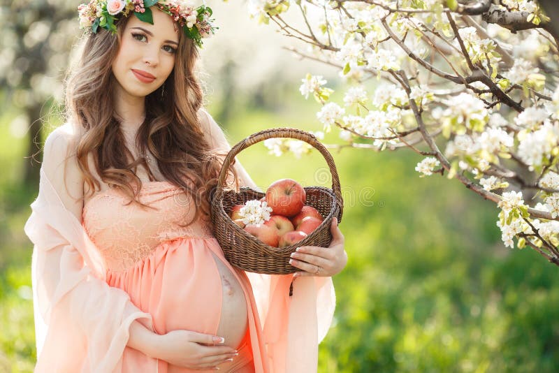 A pregnant woman in a spring garden with basket